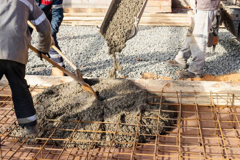 Concrete workers pour cement for a residential driveway